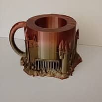 Mug imprimé en 3D en dégradé cuivré, dont la base est sculptée en muraille de château avec une herse et des tours.
