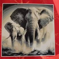 Tableau en relief noir et blanc d'un grand éléphant de face accompagné d'un éléphanteau, posé sur un fond rouge.