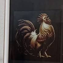 Tableau encadré représentant un coq aux plumes dorées et brunes, chantant, se détachant sur un fond noir.