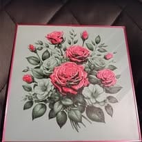 Tableau imprimé en relief représentant un bouquet de roses roses et de feuillage gris clair, dans un cadre bordé de rose.